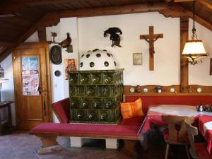 uma sala de estar com um banco e uma cruz na parede em Apartment near the ski area in Salzburg em Sankt Michael im Lungau