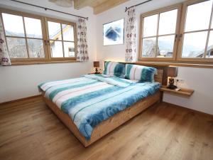 a bedroom with a bed in a room with windows at Modern chalet with garden in Salzburgerland near the Katschberg ski area in Sankt Margarethen im Lungau