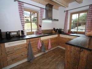 a kitchen with wooden cabinets and a sink and windows at Modern chalet with garden in Salzburgerland near the Katschberg ski area in Sankt Margarethen im Lungau