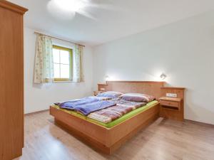 a bedroom with a wooden bed and a window at Spacious Villa with Sauna in Mittersill in Mittersill