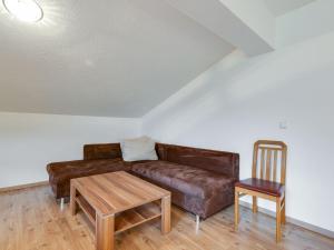 a living room with a brown couch and a wooden table at Spacious Villa with Sauna in Mittersill in Mittersill