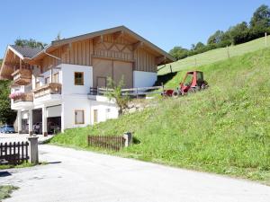 a house on a hill with a tractor in front of it at Spacious Villa with Sauna in Mittersill in Mittersill