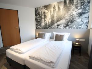 a bedroom with two beds and a painting on the wall at Modern Apartment in Sankt Margarethen im Lungau with Garden in Sankt Margarethen im Lungau