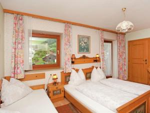 - une chambre avec 2 lits et une fenêtre dans l'établissement Beautiful Apartment in Uttendorf with Balcony, à Uttendorf