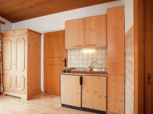 a kitchen with wooden cabinets and a sink at Beautiful Apartment in Uttendorf with Balcony in Uttendorf