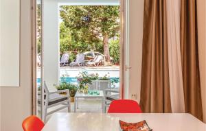 Zimmer mit Blick auf eine Terrasse mit Tischen und Stühlen in der Unterkunft Awesome Apartment In Makarska With Heated Swimming Pool in Makarska