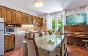 a kitchen with a glass table and a piano at Amazing Home In Podstrana With Kitchen in Podstrana