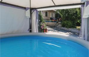 a swimming pool in a backyard with a white canopy at Amazing Home In Podstrana With Kitchen in Podstrana