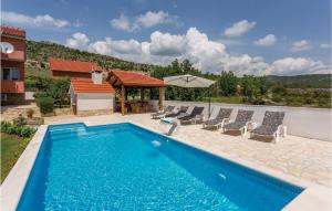 een zwembad met stoelen en een huis bij Pet Friendly Home In Brstanovo With Kitchen in Brštanovo
