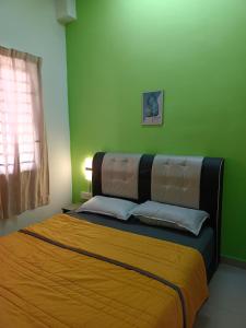 ein Schlafzimmer mit einem großen Bett mit grünen Wänden in der Unterkunft HOMESTAY D'TEPIAN CASA, BANDAR SERI IMPIAN KLUANG in Keluang