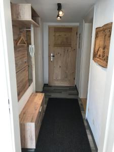 einen Flur mit einer Holztür und einer Holzbank in der Unterkunft Beim Strele in Oberstaufen