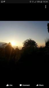 una persona está mirando la puesta de sol en una colina en Bel View Guest House, en Haputale