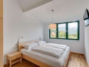 ein weißes Schlafzimmer mit einem Bett und einem Fenster in der Unterkunft Apartment in Hohentauern near ski area in Hohentauern