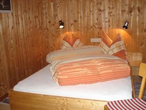 ザンクト・ガレンキルヒにあるCozy holiday home near the ski area in Sankt Gallenkirch Vorarlbergの木製の壁のドミトリールーム(ベッド1台)