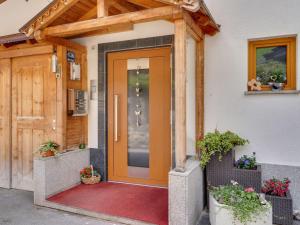 カップルにあるSpacious Apartment in Tyrol with Mountain Viewの鉢植えの家のオレンジの扉