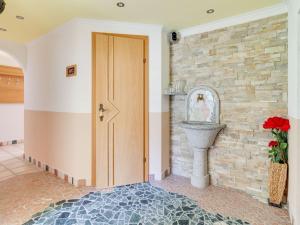 a hallway with a door and a stone wall at Spacious Apartment in Tyrol with Mountain View in Kappl