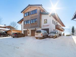 dom z dwoma samochodami zaparkowanymi przed nim w obiekcie Apartment in Saalfelden near Ski Slopes w mieście Saalfelden am Steinernen Meer