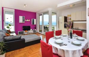 ein Wohnzimmer mit einem Tisch und roten Stühlen in der Unterkunft Awesome Apartment In Podstrana With House Sea View in Podstrana