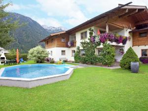 ヴァイトリングにあるCharming Apartment with Shared Pool in Waidring Tyrolの庭にスイミングプールがある家