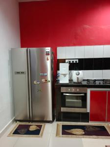 a kitchen with a stainless steel refrigerator and a stove at HOMESTAY D'TEPIAN CASA, BANDAR SERI IMPIAN KLUANG in Kluang