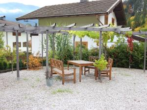 a wooden table and chairs under a pergola at Stylish authentic holiday home in Leogang Salzburgerland near ski area in Leogang