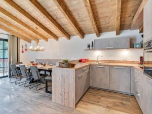 una cocina con techos de madera y una mesa con sillas. en Chalet in ski area Hochkrimml Zillertal Arena, en Krimml