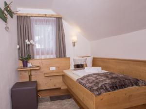 1 dormitorio con cama de madera y ventana en Delightful Holiday Home in Untertauern with Sauna, en Untertauern