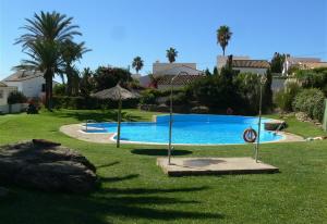 een zwembad met een parasol in de tuin bij Estepona Villa Sea Front in Estepona