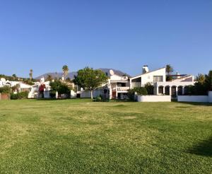 een groot grasveld met huizen op de achtergrond bij Estepona Villa Sea Front in Estepona