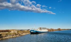 um barco azul e branco num rio em Peniche Alphonsia Maria em Villeneuve-lès-Maguelonne