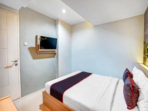 سرير أو أسرّة في غرفة في Capital O 90888 Bintang Diponggo Residence
