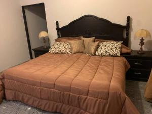 a bedroom with a large bed with pillows and a mirror at Quinta Campestre Los Encinos in Santiago