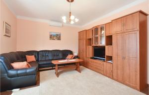 a living room with a black leather couch and a table at Lovely Home In Sinj With Outdoor Swimming Pool in Rožani