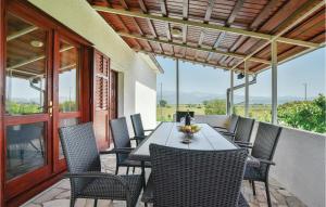 eine Terrasse mit einem Tisch und Stühlen auf dem Balkon in der Unterkunft Lovely Home In Sinj With Outdoor Swimming Pool in Rožani