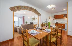 a dining room and living room with a table and chairs at Beautiful Home In Visnjan With Outdoor Swimming Pool in Višnjan