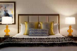 ein Schlafzimmer mit einem Bett mit Kissen und zwei Lampen in der Unterkunft Marina del Rey Hotel in Los Angeles