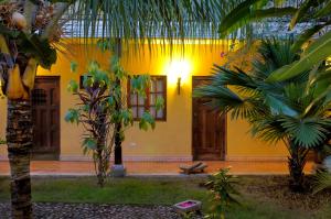 a yellow building with palm trees in front of it at Hotel La Pérgola in Granada