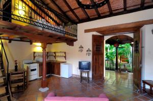 a living room with a kitchen and a tv at Hotel La P&eacute;rgola in Granada