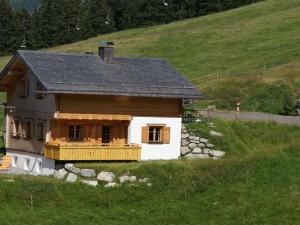 a small house on a hill in a field at Apartment with balcony in Sankt Gallenkirch in Sankt Gallenkirch