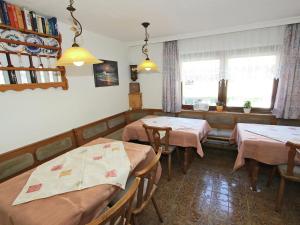 un comedor con 2 mesas y un sofá en Spacious Apartment in F gen near Ski Area, en Fügen
