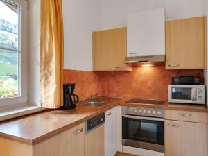 a kitchen with a sink and a microwave at Modern Apartment in Gro arl Salzburg with Sauna in Grossarl