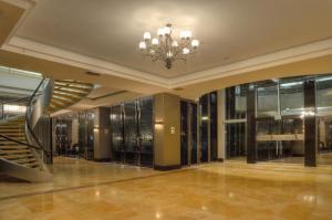 vestíbulo con escalera y lámpara de araña en Sol de Oro Hotel & Suites, en Lima