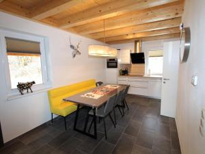 ケットシャッハにあるModern Chalet in K tschach Mauthen with Private Terraceのキッチン、ダイニングルーム(テーブル、黄色い椅子付)