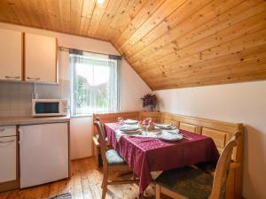 a dining room with a table and a microwave and a kitchen at Holiday home in Sankt Andr near ski area in Reisberg