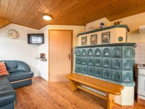 a living room with a green fireplace and a couch at Holiday home in Sankt Andr near ski area in Reisberg