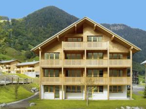 a large wooden house with a mountain in the background at Apartment at the ski lift in Brand in Vorarlberg in Brand