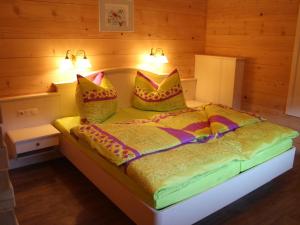 レオガングにあるSpacious Apartment with Sauna in Leogangのベッドルーム1室(カラフルな毛布と枕付きのベッド1台付)