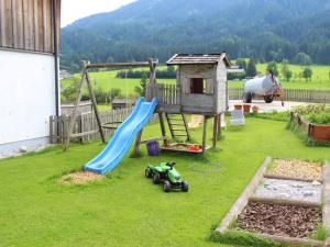 einen Spielplatz mit Rutsche und Spielzeugauto auf dem Rasen in der Unterkunft Spacious Apartment with Sauna in Leogang in Leogang