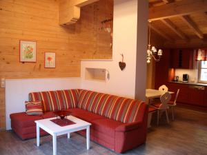 a living room with a red couch and a table at Spacious Apartment with Sauna in Leogang in Leogang