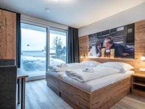 マウテルンドルフにあるHoliday home in Mauterndorf near ski areaのベッドルーム1室(大型ベッド1台、壁にポスター付)